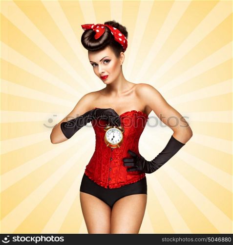 Glamorous pinup girl in a red vintage corset holding a retro alarm clock in her hand and posing on colorful abstract cartoon style background.