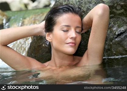 Glamorous woman showering in natural springs
