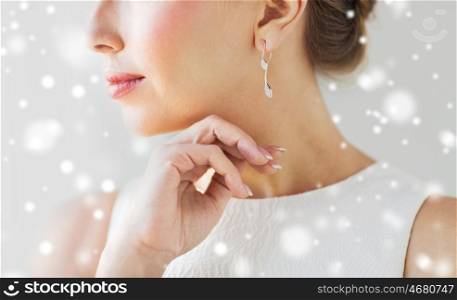 glamour, beauty, jewelry and luxury concept - close up of beautiful woman face with gold and diamond earring