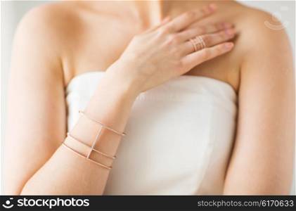 glamour, beauty, jewelry and luxury concept - close up of beautiful woman with golden ring and bracelet