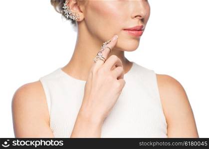 glamour, beauty, jewelry and luxury concept - close up of beautiful woman with golden ring and diamond earring