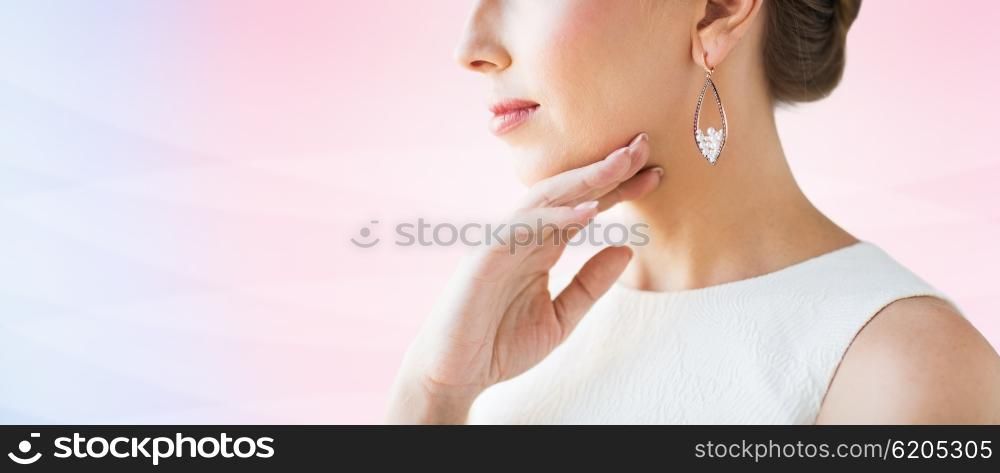 glamour, beauty, jewelry and luxury concept - close up of beautiful woman face with pearl earring over rose quartz and serenity gradient background
