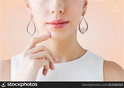 glamour, beauty, jewelry and luxury concept - close up of beautiful woman face with pearl earrings over beige background