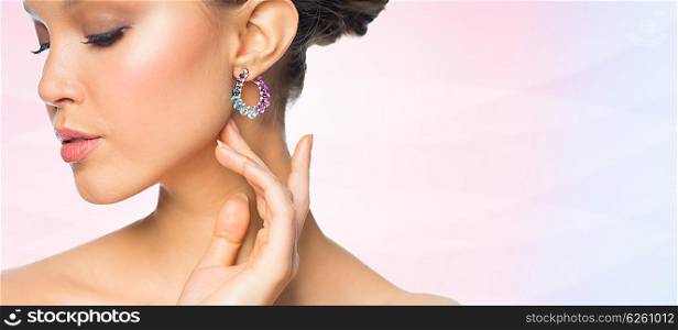 glamour, beauty, jewelry and luxury concept - close up of beautiful woman face with earring over rose quartz and serenity gradient background