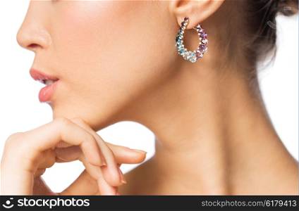 glamour, beauty, jewelry and luxury concept - close up of beautiful woman face with earring