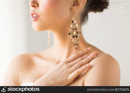 glamour, beauty, jewelry and luxury concept - close up of beautiful woman with earrings