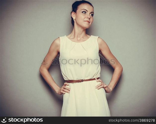 Glamour girl bright dress on gray. Fashion young woman posing. Studio photo, filtered tone