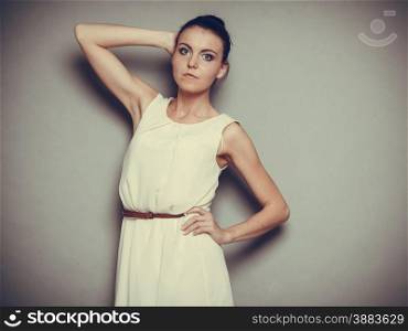 Glamour girl bright dress on gray. Fashion young woman posing. Studio photo, filtered tone