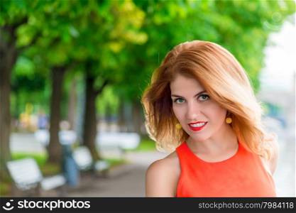 Glamour girl&rsquo;s face with red lips in park