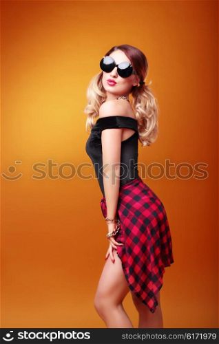 Glamour girl wearing sunglasses against the bright background.