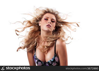 glamour portrait of a sensual blonde wearing a coloured bra and throwing her long hair