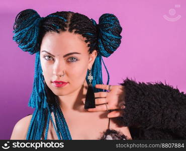 Glamour portrait of sexy woman with african blue braids hairstyle, bindi, nose ring and tassel earrings isolated on colorful background.. Glamour fashionable portrait of sexy woman with african blue braids hairstyle, bindi, nose ring and tassel earrings isolated on colorful background. Disco style. Hipster girl.