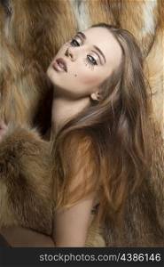 glamour portrait of sexy young girl with long smooth hair, creative make-up on fur background