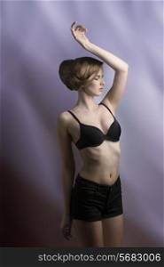 glamour shoot of young lady posing with black bra, sexy shorts and elegant hair-style, fashion pose and perfect body