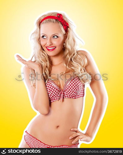 glamour shot of a pin up girl in red lingerie ready for a sexy christmas party with a red bow on hair on yellow background