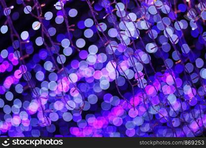 Glamour Ultra Violet sparkling and purple glitter bokeh. Multicolored Christmas and New Year glowing light abstract bokeh and blurred background.Christmas and holiday concept.