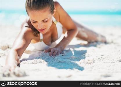 Glamour young woman in swimsuit laying on beach