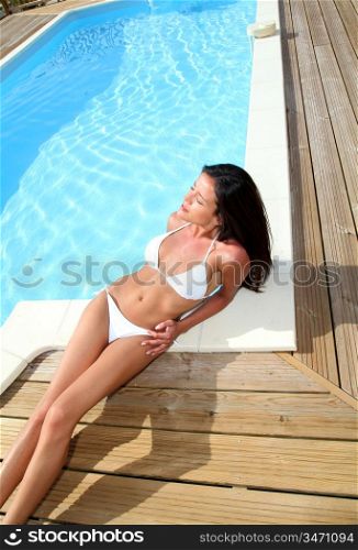 Glamourous woman relaxing by swimming-pool