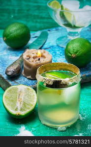 glass alcoholic drink and lime fruits on wooden texture.Selective focus. refreshing cocktail made of rum and lime with ice