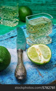 glass alcoholic drink and lime fruits on wooden texture.Selective focus. alcoholic cocktail with additions of lime