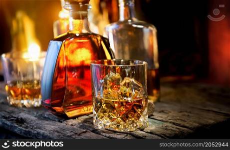 Glass and bottle of whiskey on a wooden table
