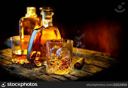 Glass and bottle of whiskey on a wooden table