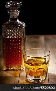 glass and bottle of whiskey on wooden table