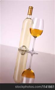Glass and bottle of white wine over a white background