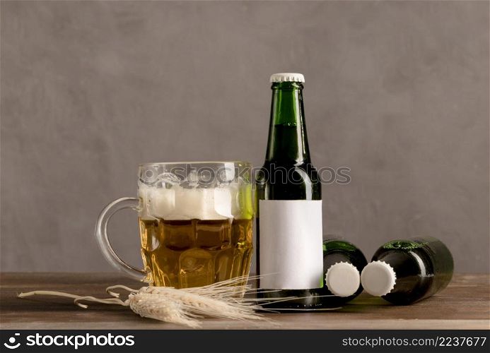 glass beer with foam green bottles beer wooden table