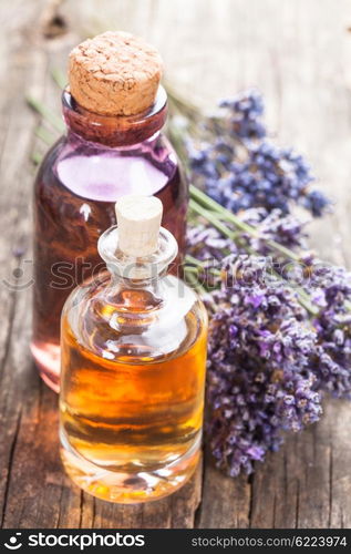 Glass bottle of essential oil and dry lavender bunch. Spa concept. The essential oil