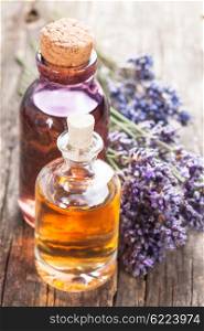 Glass bottle of essential oil and dry lavender bunch. Spa concept. The essential oil