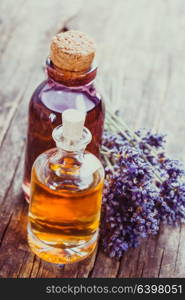 Glass bottle of essential oil and dry lavender bunch. Spa concept. The essential oil