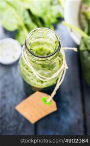 Glass bottle of green smoothie, close up