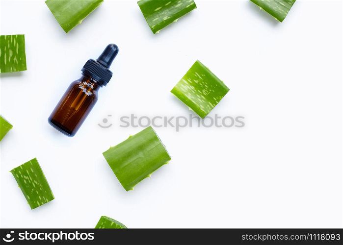Glass bottle of products for spa or skin care cosmetic with aloe vera leaves cut pieces isolated on white background. Copy space
