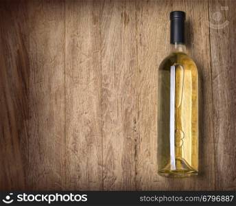 Glass bottle of wine on wooden table background