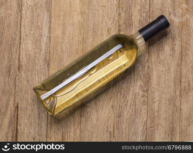 Glass bottle of wine on wooden table background