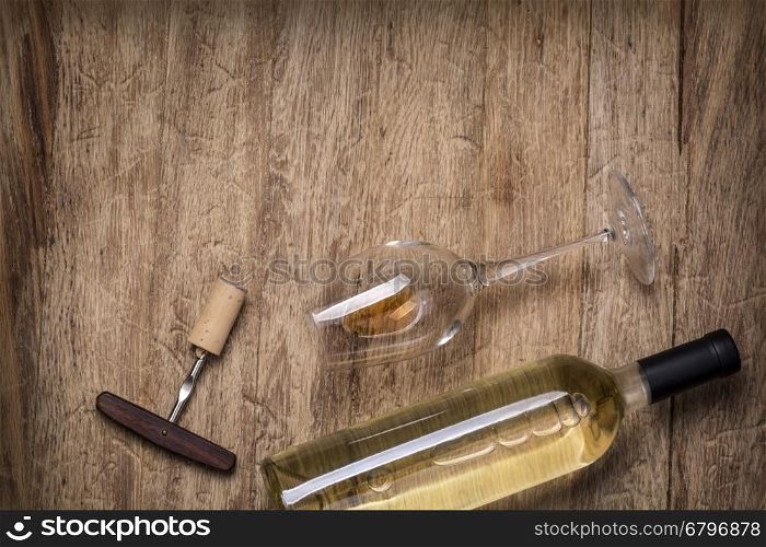 Glass bottle of wine with corks on wooden table background