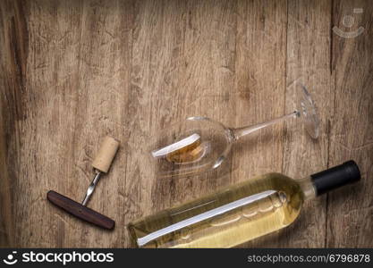 Glass bottle of wine with corks on wooden table background