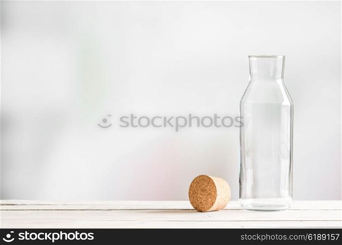 Glass bottle with a brown cork on a wooden table