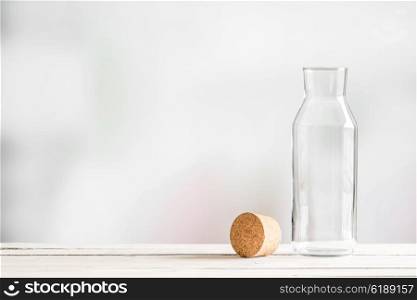 Glass bottle with a brown cork on a wooden table
