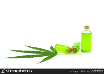Glass bottle with CBD oil and cannabis leaf at the background, medical marijuana concept