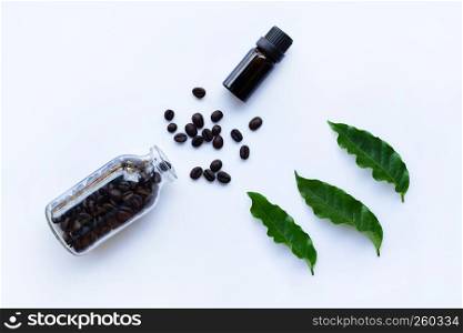 Glass bottle with essential oil of coffee and Coffee grains on white background