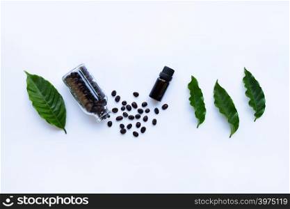 Glass bottle with essential oil of coffee on white background