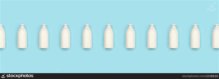 Glass bottles of milk in a row on blue background. Flat lay Top view Banner Copy space.. Glass bottles of milk in a row on blue background. Flat lay Top view Banner Copy space