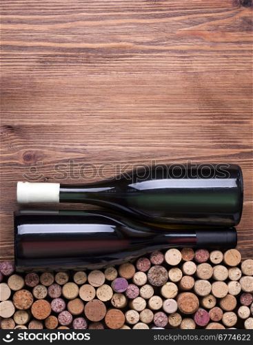 Glass bottles of wine with corks on wooden table background