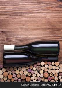 Glass bottles of wine with corks on wooden table background