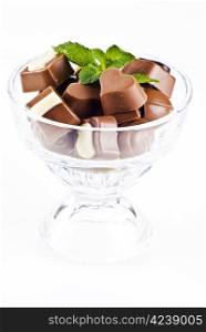 Glass bowl of assorted chocolates and mint