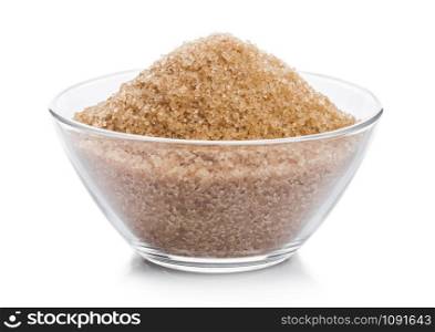 Glass bowl of natural brown refined sugar on white.