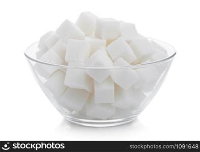 Glass bowl of natural white sugar cubes on white.