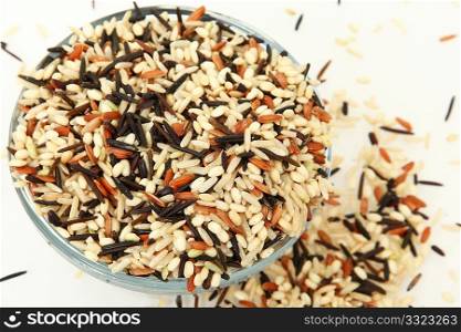 Glass bowl of various whole grain rice. Brown, wild, black, long, short, medium, paddy, wax, rough, arborio, jasmine, japonica, della, delrose, delmont, sweet,